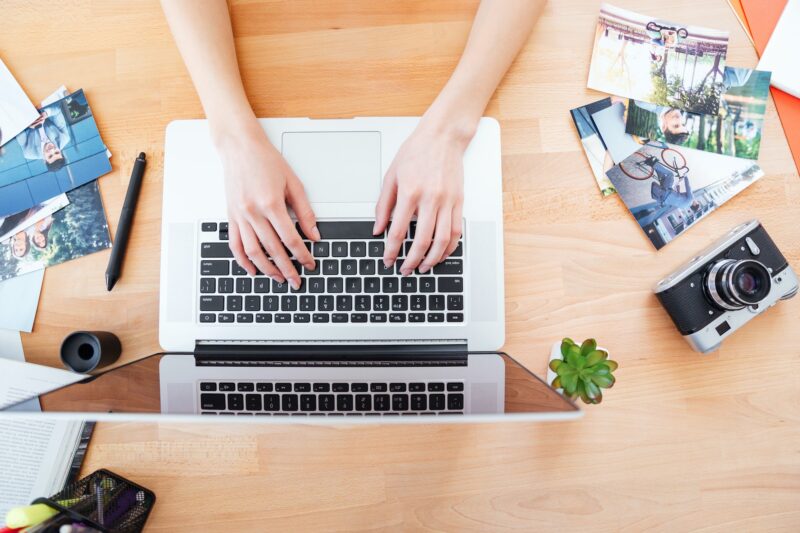 Desktop of young woman photographer working with laptop