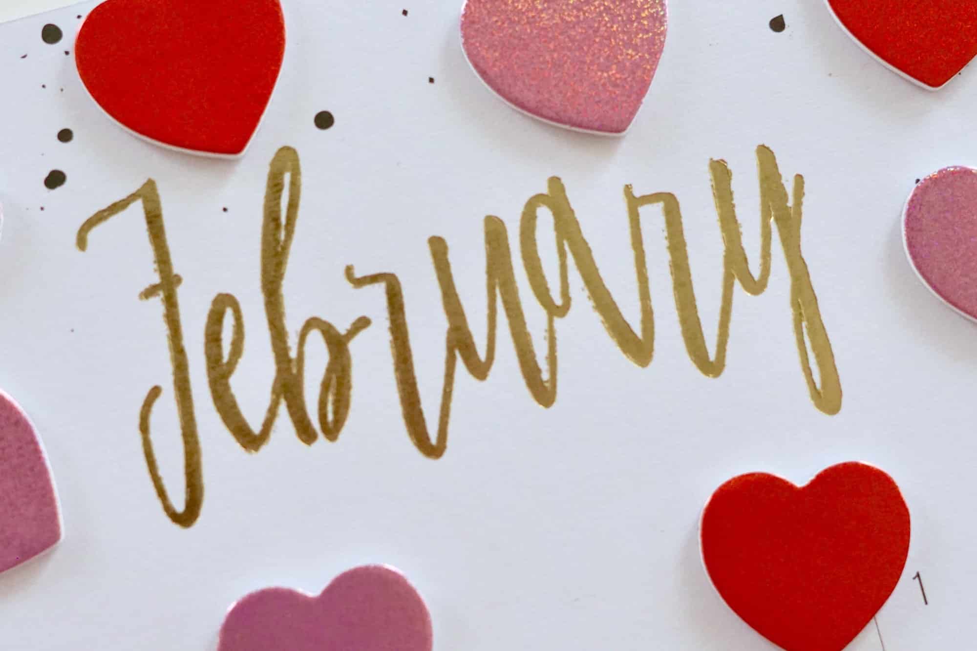 February in gold letters surrounded by pink and red hearts