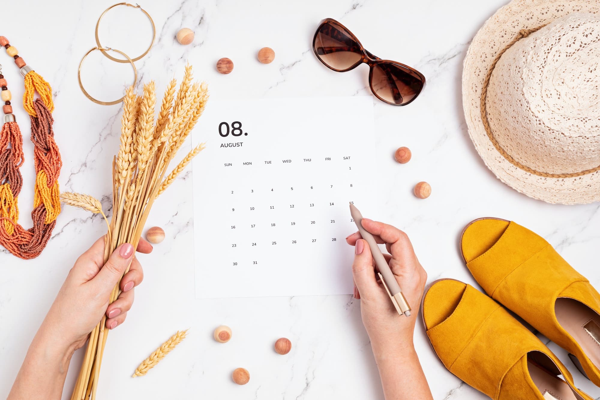 Flat lay with calendar for August with summer holidays fashion accessories