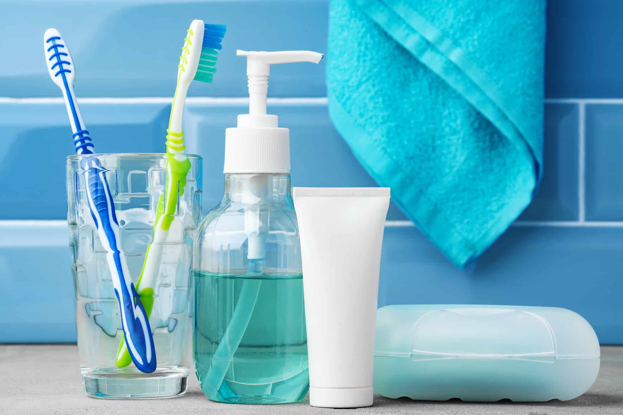 The toothbrushes in a glass in blue bathroom