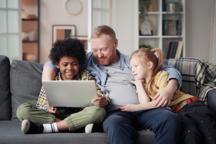 Father with children using laptop at home