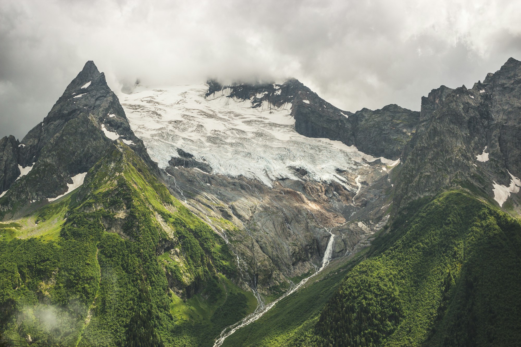 Mountains With Green Grass And Stormy Sky