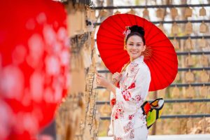 Portrait close up of pretty young woman wear japanese style dress and hold red umbrella